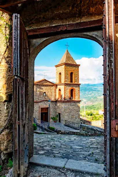 Picturesque shot of historic village Castelnuovo at the Cilento national reserve in Italy. The medieval door opens for its historic church.
