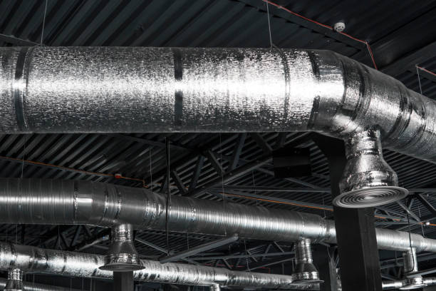 istock Ventilation system on the ceiling of large buildings. Ventilation pipes in silver insulation material hanging from the ceiling inside new building. 994145338