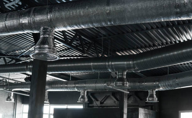 istock Ventilation system on the ceiling of large buildings. Ventilation pipes in silver insulation material hanging from the ceiling inside new building. 994147626
