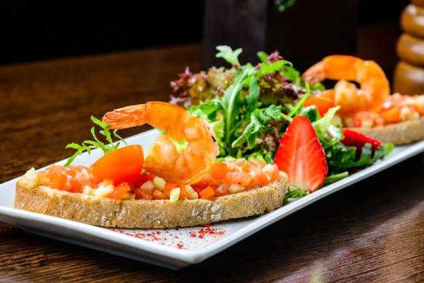 istock Delicious seafood dish. Bread with tomatoes and shrimps and basi 994147950