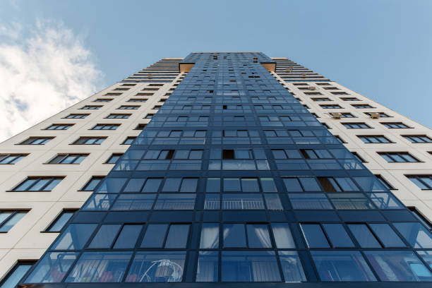 istock tall apartment house against the blue sky. Bottom view 994148388