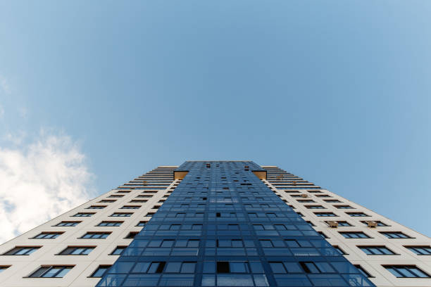 istock tall apartment house against the blue sky. Bottom view 994148400