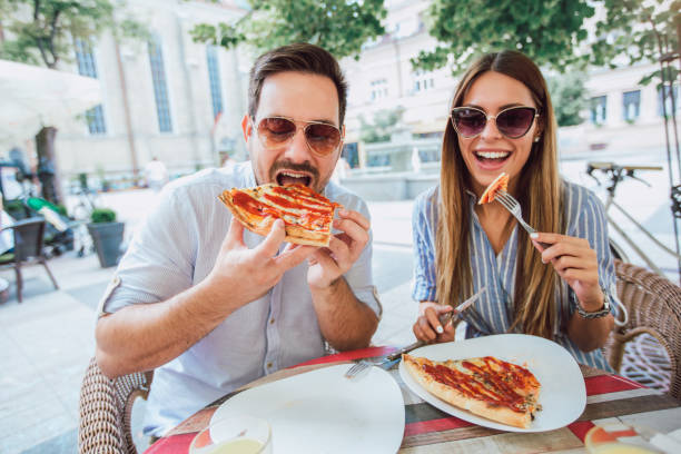 istock Couple eating pizza snack outdoors 994152520
