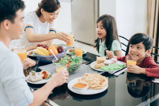 familia disfruta de comida sana - los niños y los padres brindis bebidas mientras almuerza fotografías e imágenes de stock