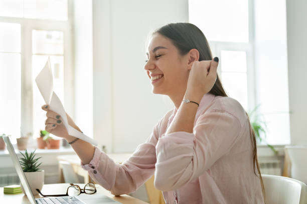 Happy female employee excited reading promotion letter Happy female worker excited getting business letter with promotion news, satisfied woman celebrating corporate success reading report with great result or personal achievement. Rewarding concept teen wishing stock pictures, royalty-free photos & images