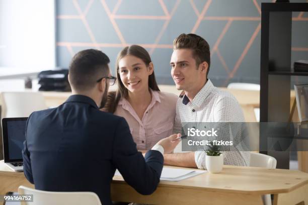 Insurance Agent Consulting Millennial Couple In Office Stock Photo - Download Image Now