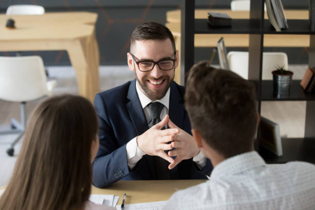 istock Smiling broker laughing consulting clients in office 994164786