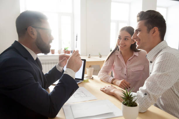 Male architect discussing house project with young couple