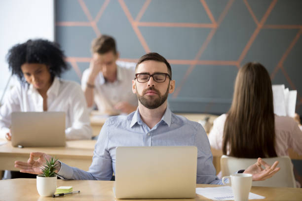istock Calm male worker meditating in lotus position at workplace 994164944