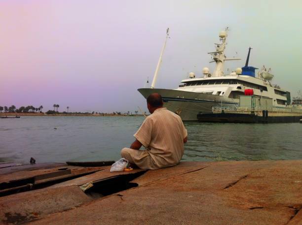 Basra, Iraq - April 12, 2014: A fisherman is fishing for his lunch with traditional clothes just near by Shatt-Al Arab River.
