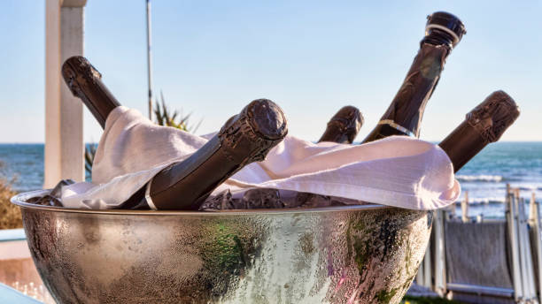 Bottles of chilled champagne inside a metallic container full of ice - selective focus