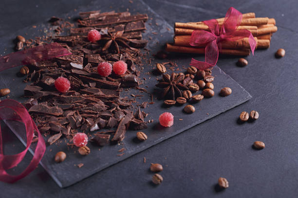 istock Dark chopping chocolate, black roasted coffee beans, red berries on dark background 994185324