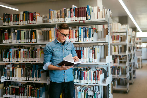 istock Student Reading Book In College Library 994198142