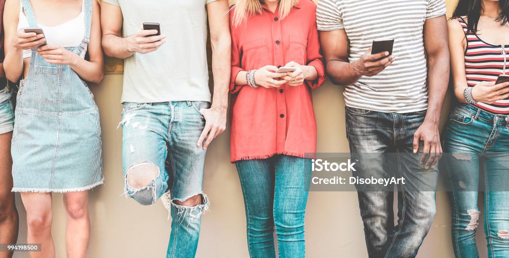 Grupo de amigos milenares vendo celulares inteligentes - vício de adolescentes, a nova tecnologia tendências - conceito de juventude, tecnologia, social e de amizade - foco em smartphones - Foto de stock de Geração Millennial royalty-free