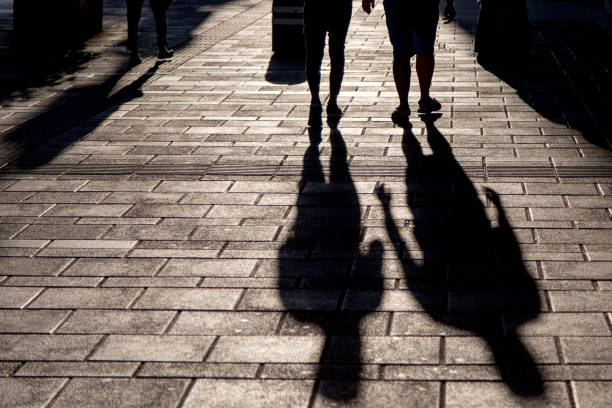 istock Legs and shadow of people walking 994201348