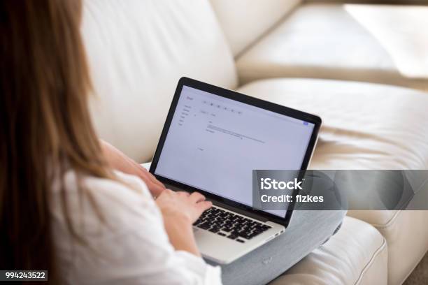 Rear View At Woman Writing Email On Laptop At Home Stock Photo - Download Image Now - E-Mail, Writing - Activity, Laptop