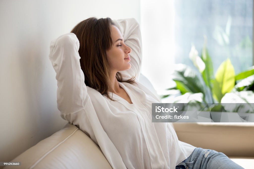 Femme décontractée, respirer l’air frais à la maison sur le canapé de repos - Photo de Femmes libre de droits