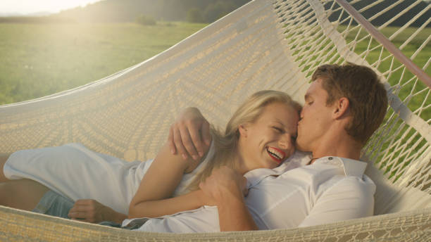 istock CLOSE UP: Joyful man kisses girlfriend on forehead while lying in romantic sling 994257888
