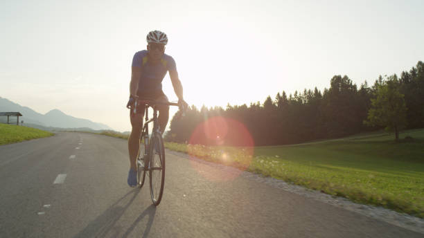 istock SUN FLARE: Young athlete rides his bicycle through picturesque summer nature 994258466