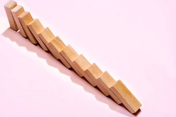 istock Domino block. Dominoes continuous toppled on pink background. 994258612