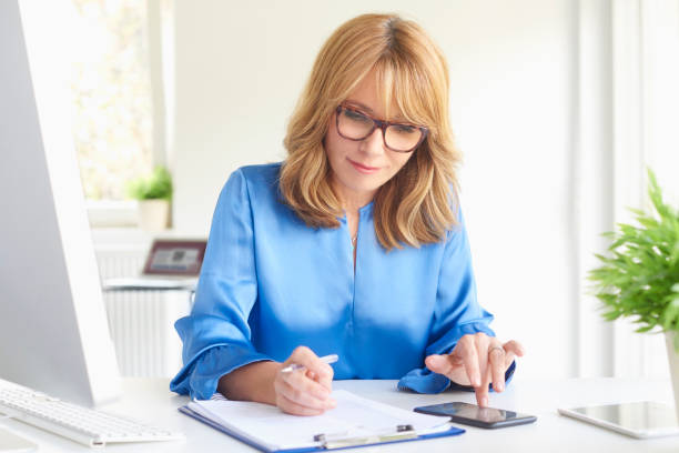 beautiful middle aged financial advisor businesswoman - multi tasking efficiency financial advisor business imagens e fotografias de stock