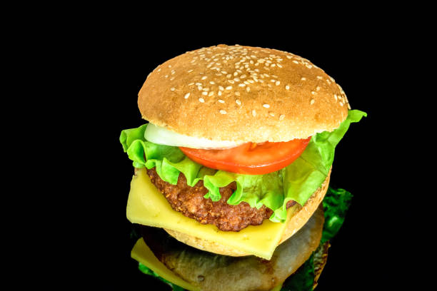 istock Big fat hamburger with fresh vegetables with reflection isolated on black background 994259990
