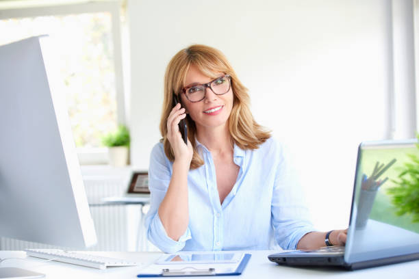 istock Successful businesswoman using her mobile phone at the office 994260002