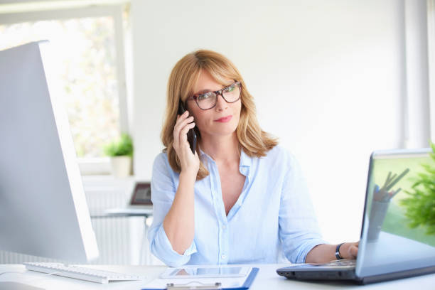 istock Successful businesswoman using her mobile phone at the office 994260008