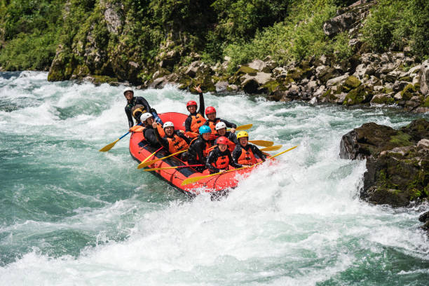 istock Group of nine men white water river rafting together 994263228