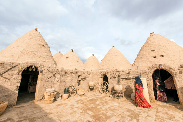 Woman walking in front of mud brick house of Harran stock photo