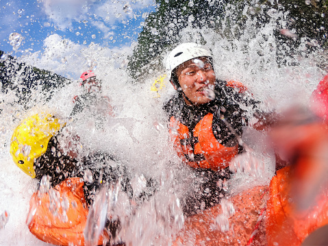 Personal point of view of a group of men and women while white water river rafting