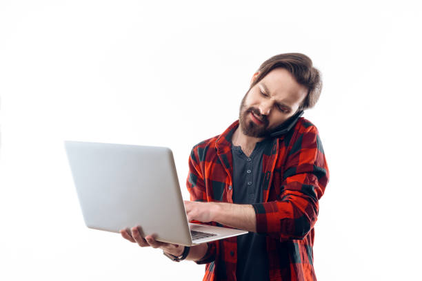 istock Angry Man Working on Laptop and Talking on Phone 994266898