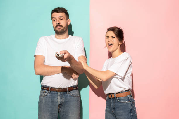 istock young couple watching tv and fighting to get the remote control 994269778