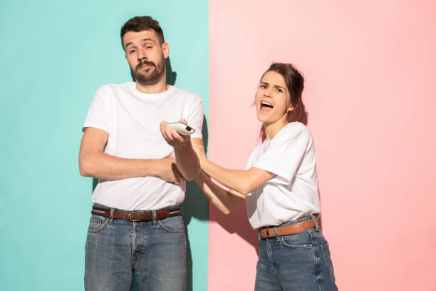 istock young couple watching tv and fighting to get the remote control 994269856