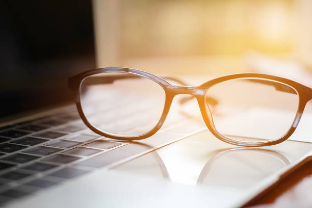 istock Eyes glasses put on computer laptop at business workplace in office with light background 994270210
