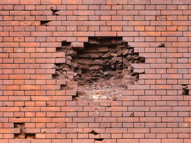 istock Echoes of war. Wall damaged by a military projectile (bomb), broken red brickwork. Brest fortress, exterior, fortification 994274036