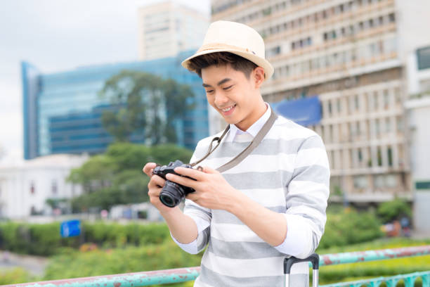 istock Attractive young man, student or freelance photographer smiles and laughs into camera 994276574