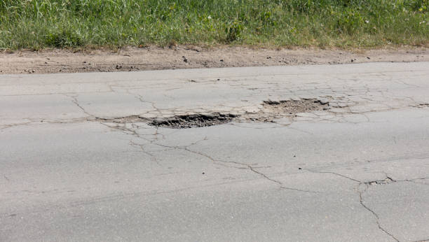 istock bad asphalt road, pit on the road 994277086