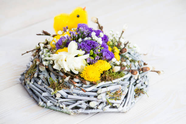 istock happy easter, yellow chick in the nest, fresh flowers 994277536