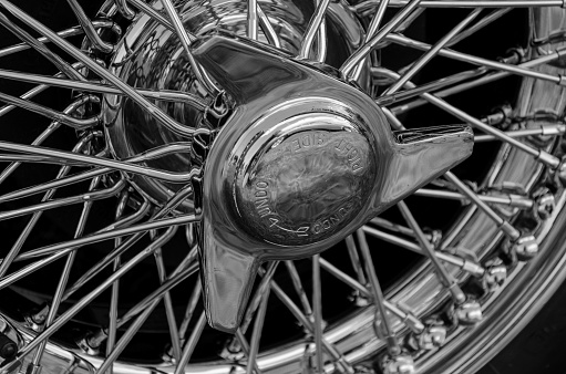 A detailed view of a chromium plated wire wheel. The wheel is usually found on classic motor vehicles.