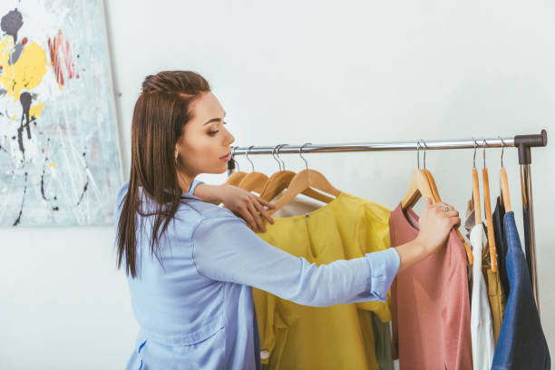 istock attractive designer looking at shirts on hangers 994284450