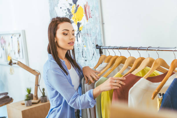 istock beautiful designer looking at clothes on hangers 994284570