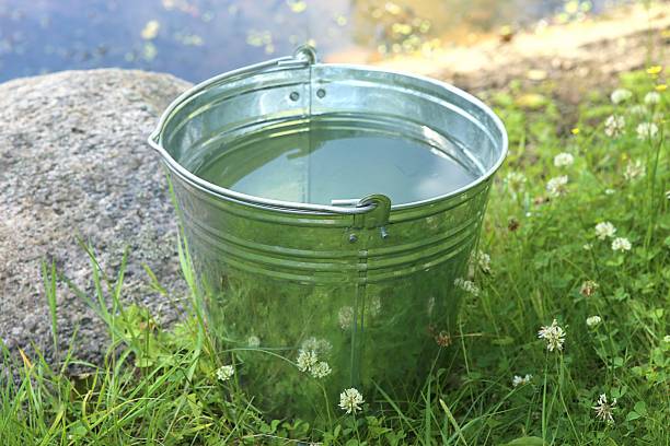 istock Metal bucket with fresh clear water. 994285124