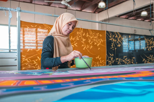istock Woman painting in a batik workshop 994288150