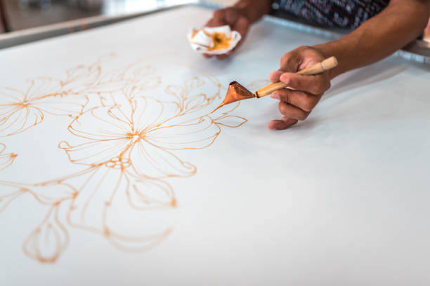 istock Man painting in a batik workshop 994288248