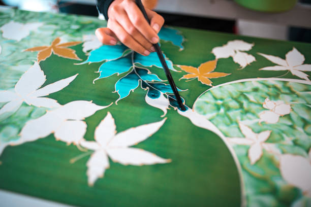 Close-up shot of woman painting in a batik workshop in Kuala Lumpur, Malaysia.