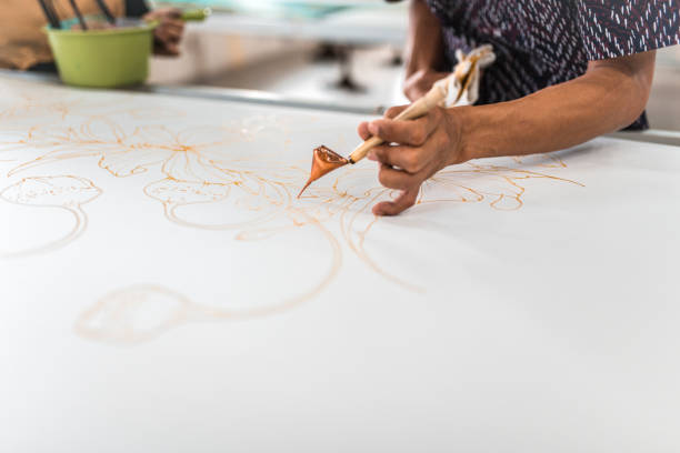 istock Man painting in a batik workshop 994288350