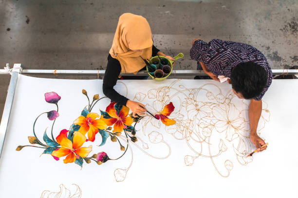 Coworkers painting in a batik workshop