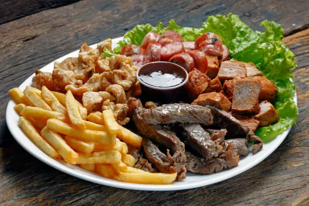 Photo of Snacks with fries, crackers, meat, pork, sausage and babercue sauce