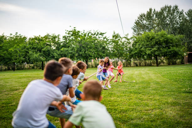 istock Group of children pulling a rope in public park 994298208